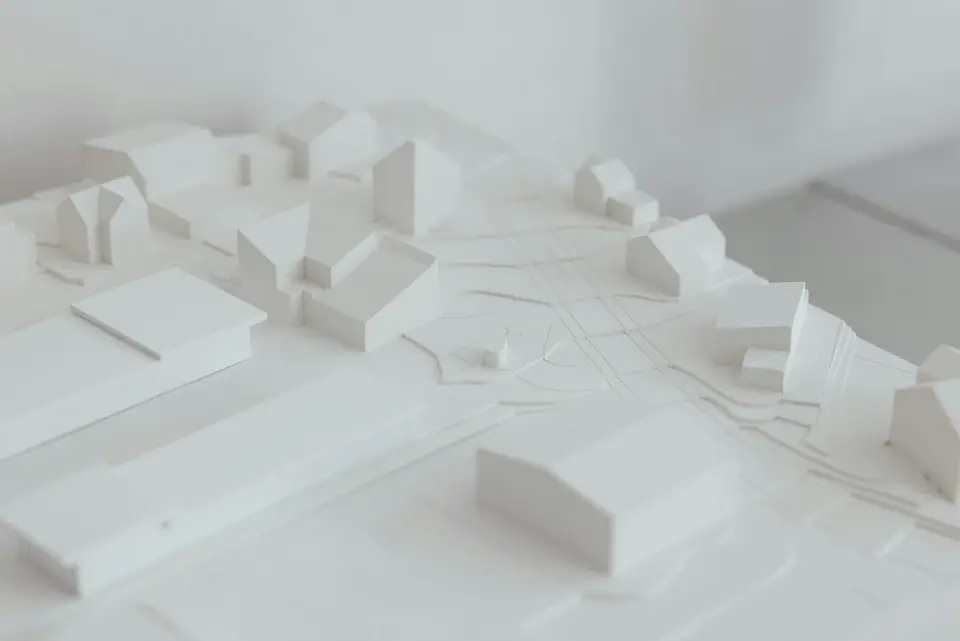 Een witte maquette van een woonwijk, met blokjes voor de huizen en de lijnen van de straten